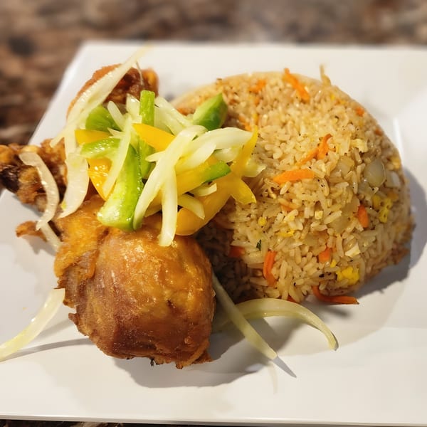 Safari77 Cuisine's fried chicken with colorful bell peppers and onions, alongside a mound of rice.